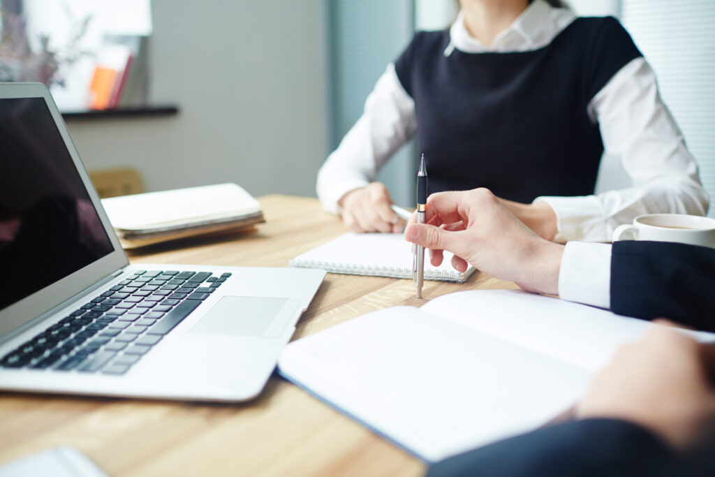 Analitycy z notatnikami dyskutują przy biurku, przygotowując się do seminarium