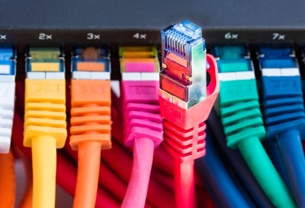 Kolorowe kable sieciowe podłączone do przełącznika w wynajmowanym mieszkaniu